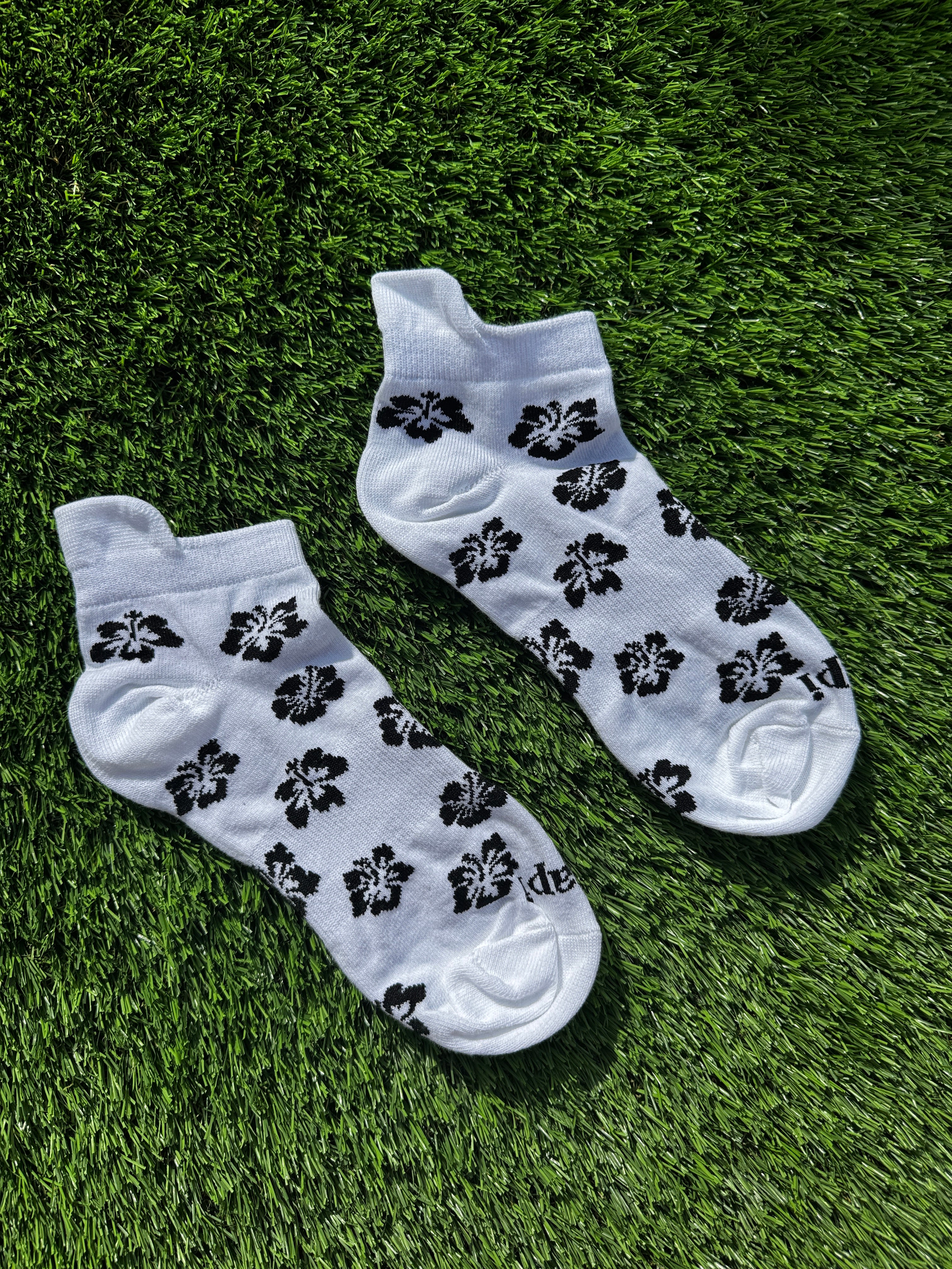 Black hibiscus ankle socks flat lay showing full hibiscus flower pattern detail