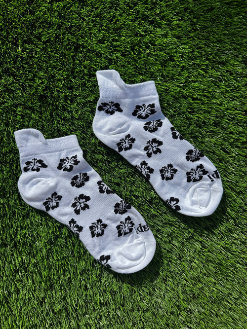 Black hibiscus ankle socks flat lay showing full hibiscus flower pattern detail