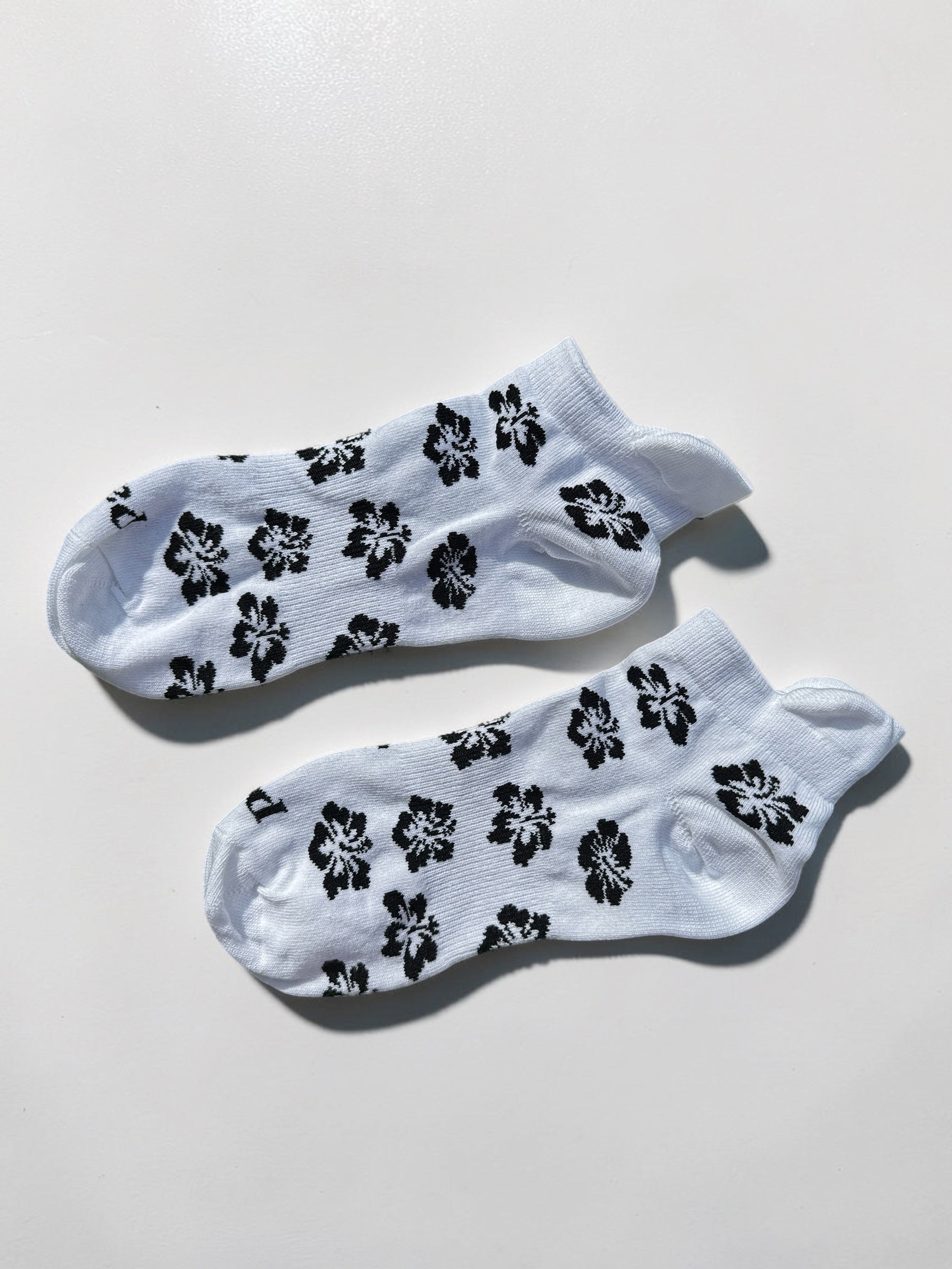Black hibiscus ankle socks on white background with tropical floral print, 100% cotton made in USA