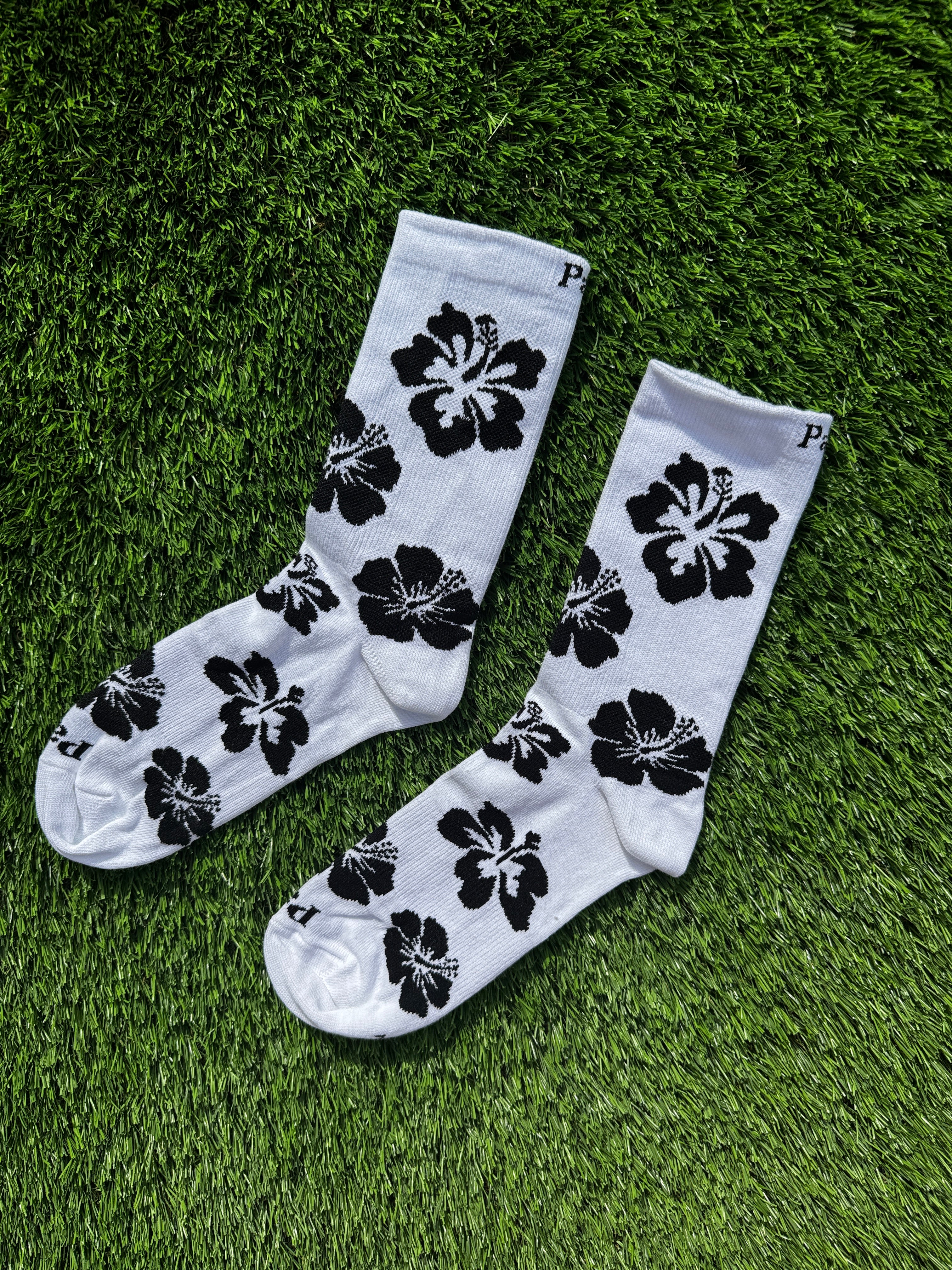 Black hibiscus crew socks side view showing tropical floral design, premium combed cotton