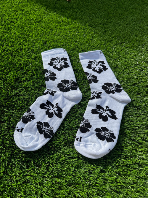 Black hibiscus crew socks flat lay showing full hibiscus flower pattern detail
